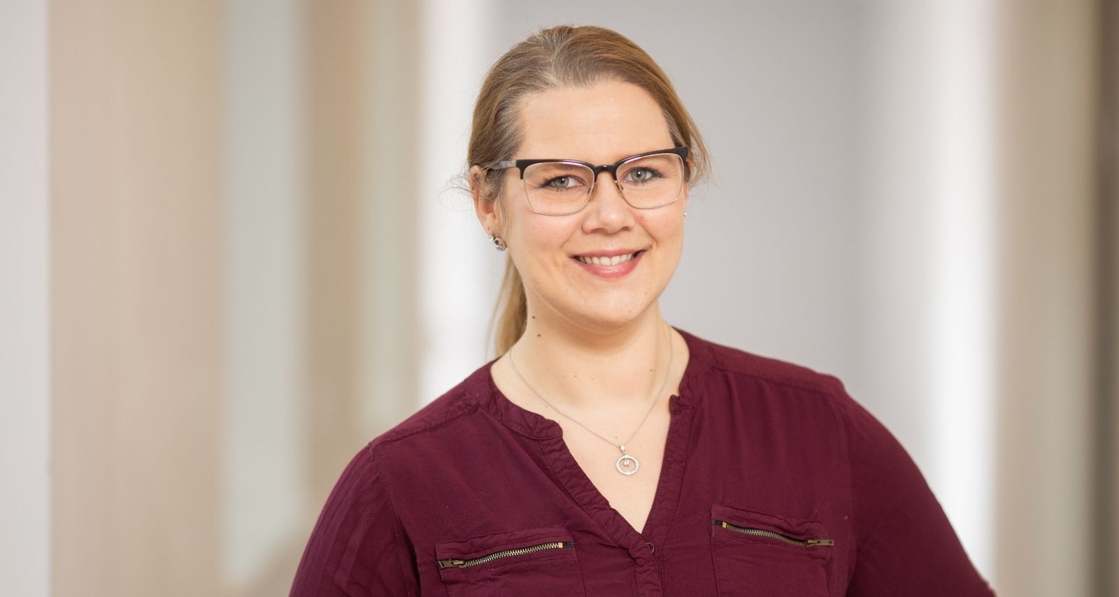 Eine Frau mit rotem Oberteil ist am lächeln 