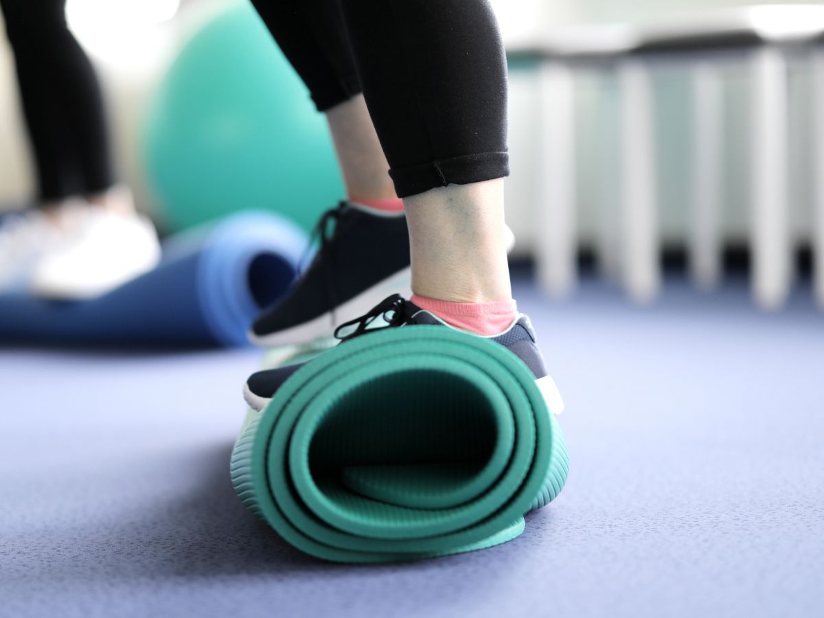Balanceübung auf einer zusammengerollten Matte während der Erweiterten Ambulanten Physiotherapie.