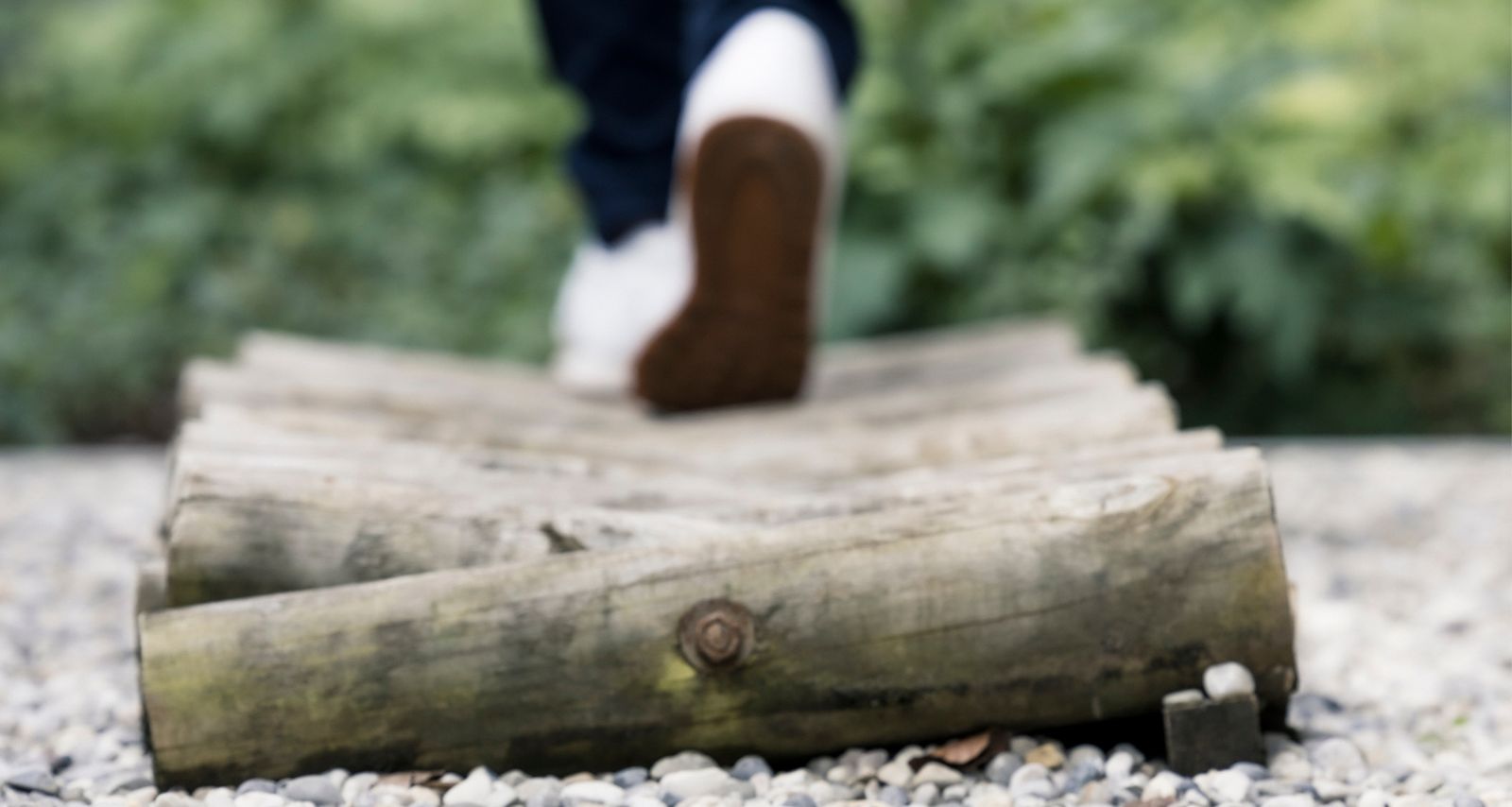 Eine Person die über Holzstämme läuft 