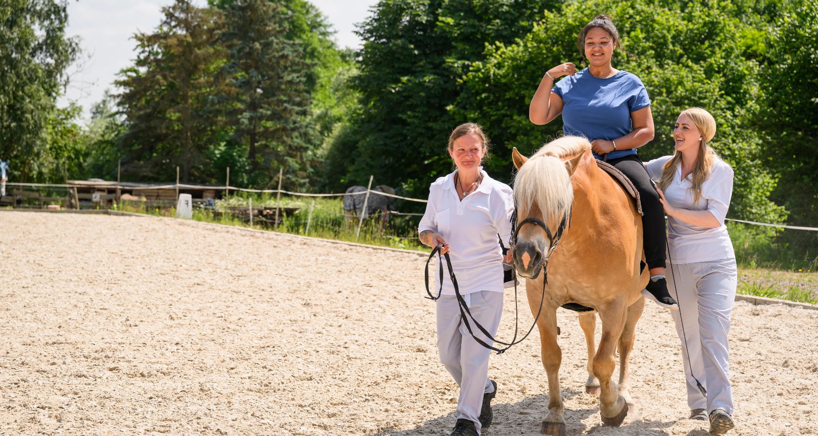 Patientin auf dem Pferd in Bergleitung von Therapeuten
