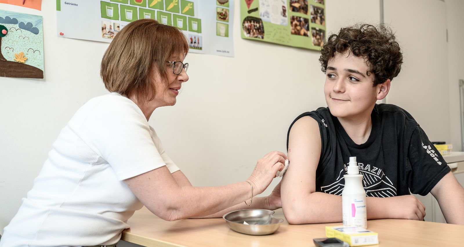 Eine Frau legt einem Jungen einen Diabetes-Sensor an