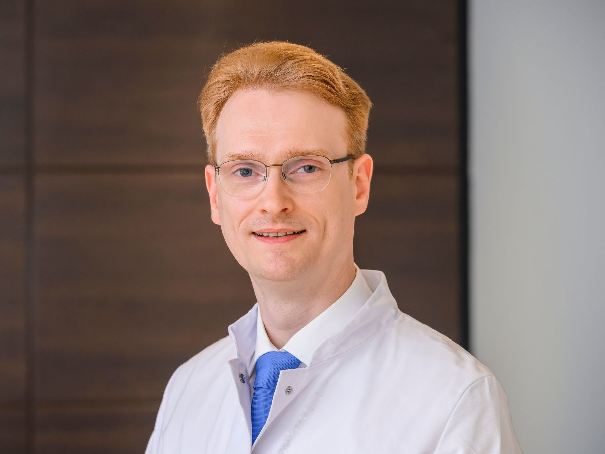 Arzt mit rötlichem Haar und Brille