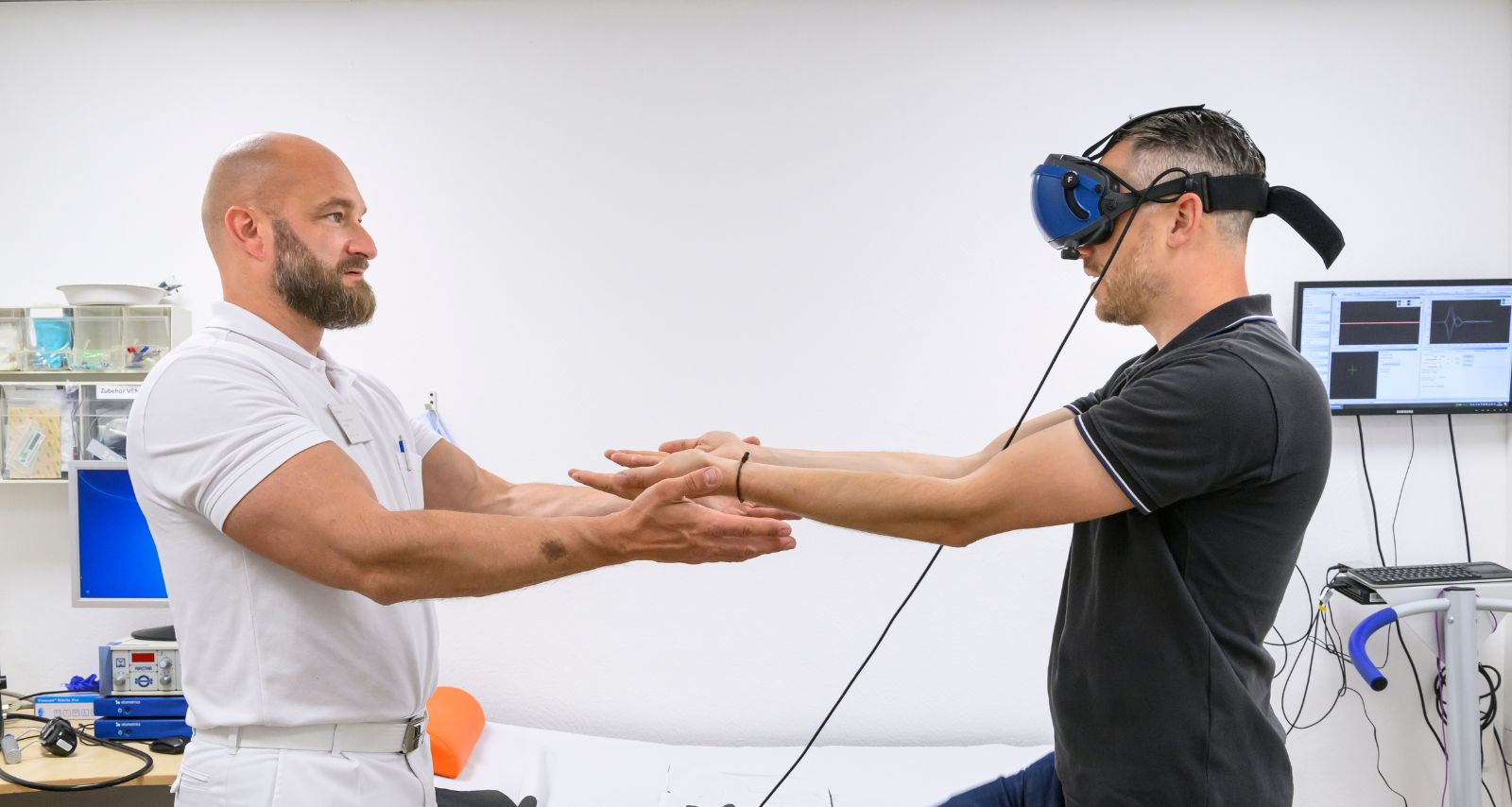 Therapeut nimmt Patienten mit VR-Brille an die Hand und prüft das Gleichgewicht