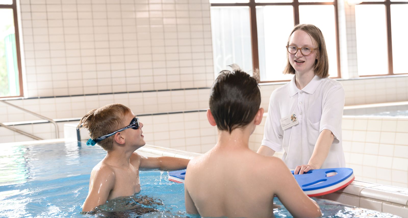 Die Therapeutin führt die Therapie durch, bei der zwei Kinder auf dem Boden liegen