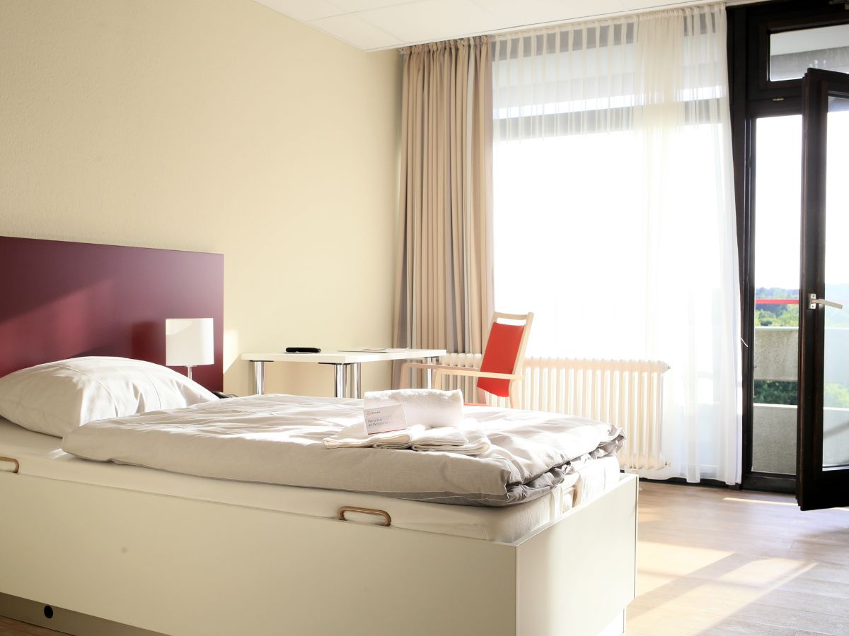 helles Einzelzimmer mit Tisch und Stühlen