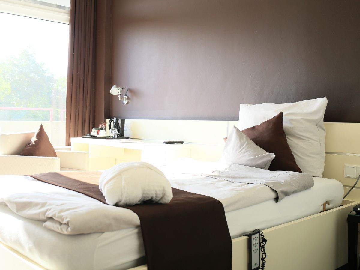 Einzelzimmer mit Komfortbett, Sessel und Tisch