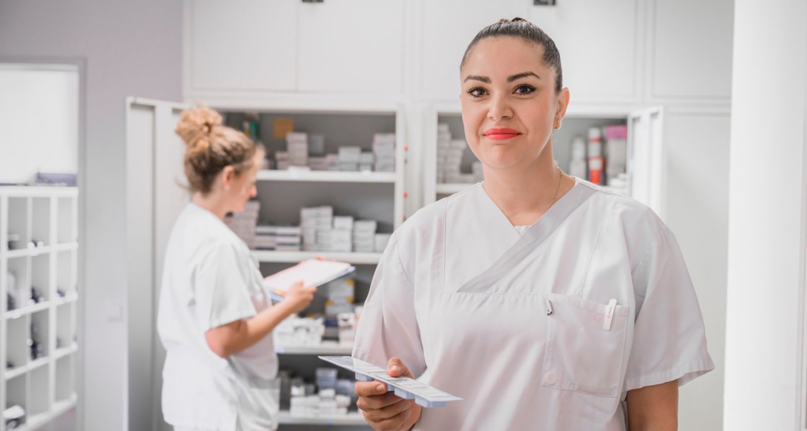 Eine Frau mit weißer Arbeitskleidung ist am lächeln