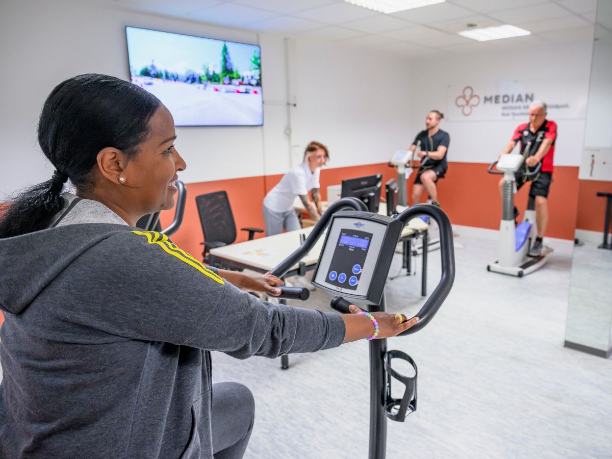 Personen die auf Ergometern trainieren 