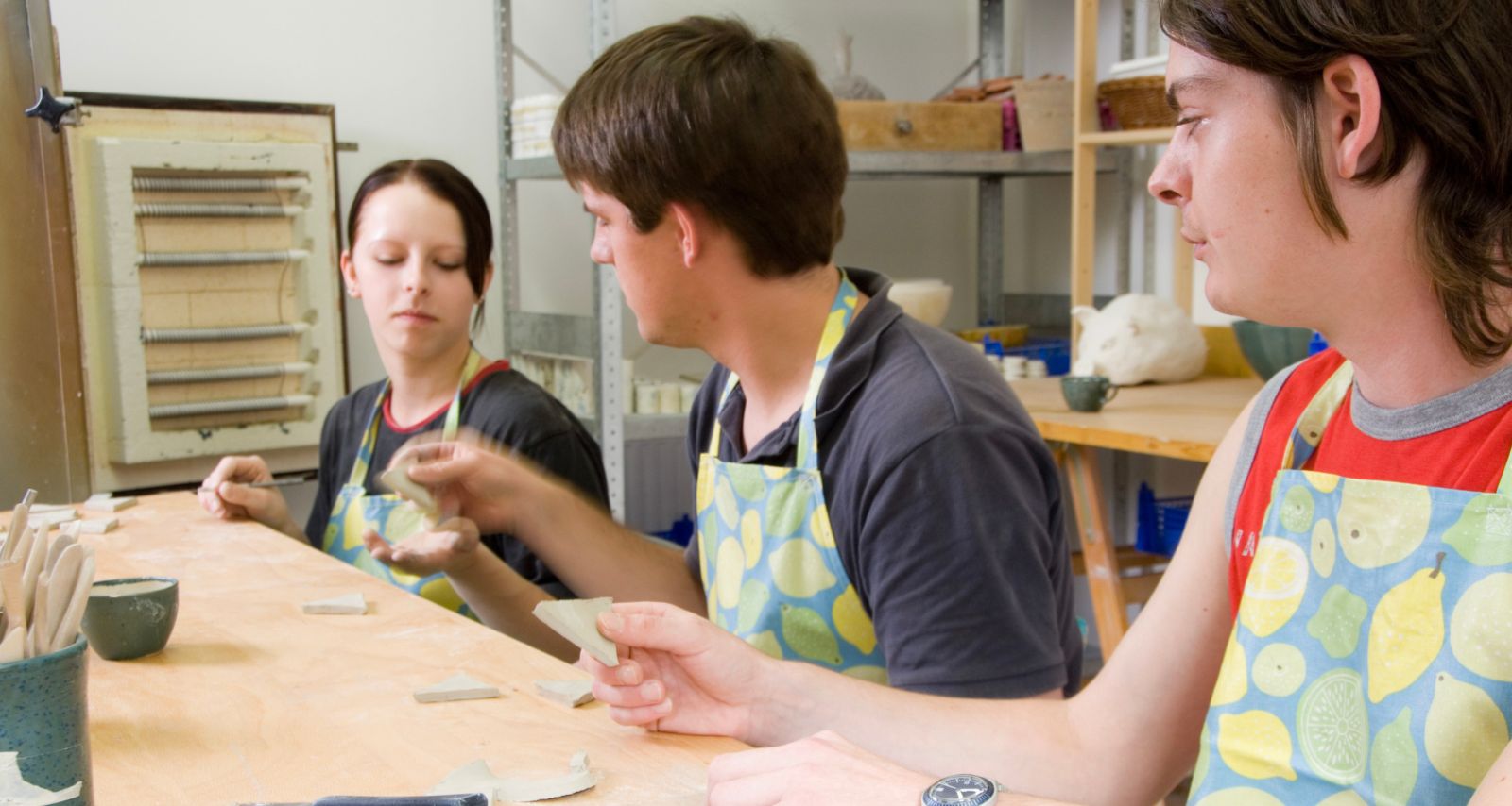 Drei Personen die gemeinsam mit Ton arbeiten 