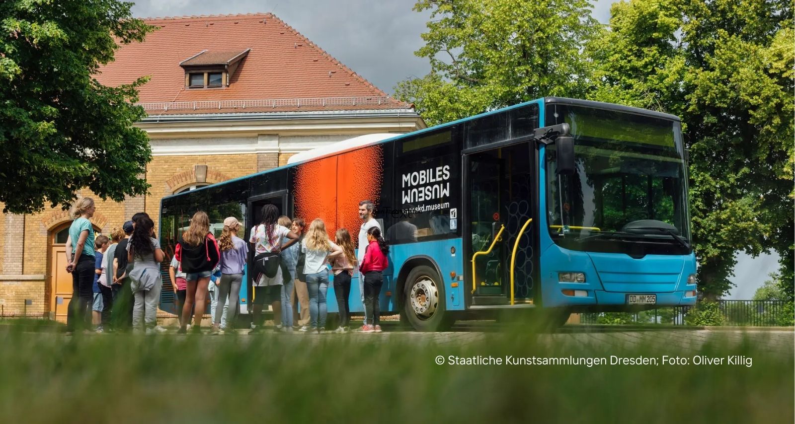 Eine Gruppe Kinder die vor einem Bus stehen 