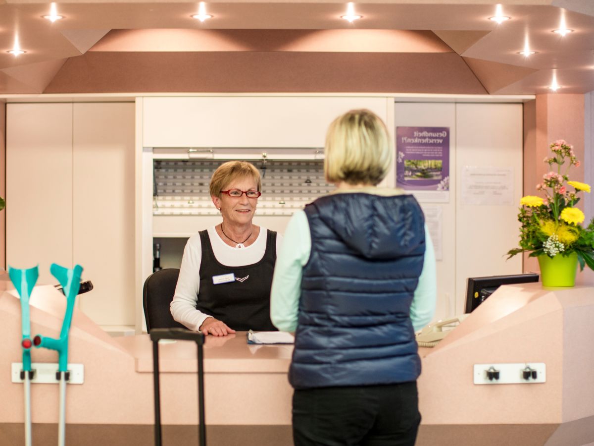 Rezeptionistin und Patientin an der Rezeption