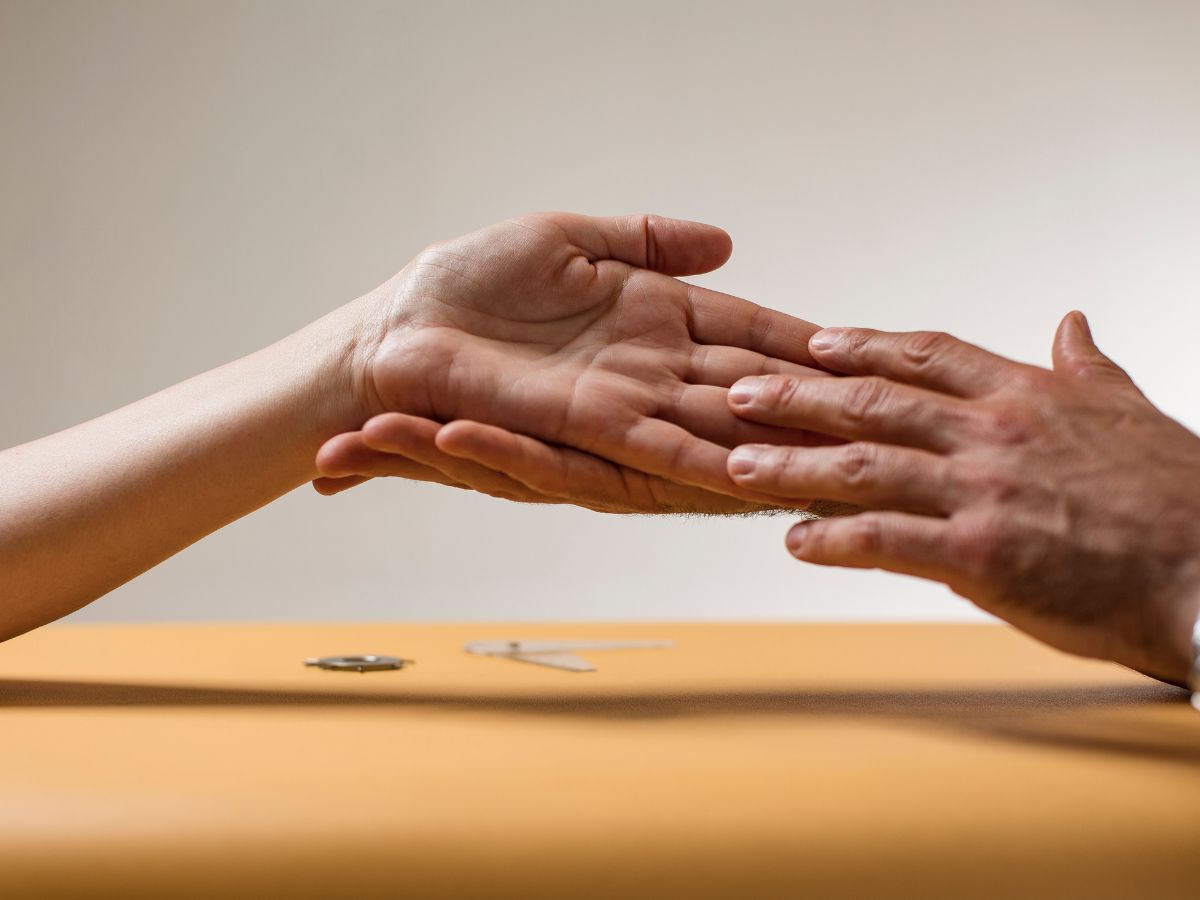 Patientenhand wird von Therapeuten untersucht