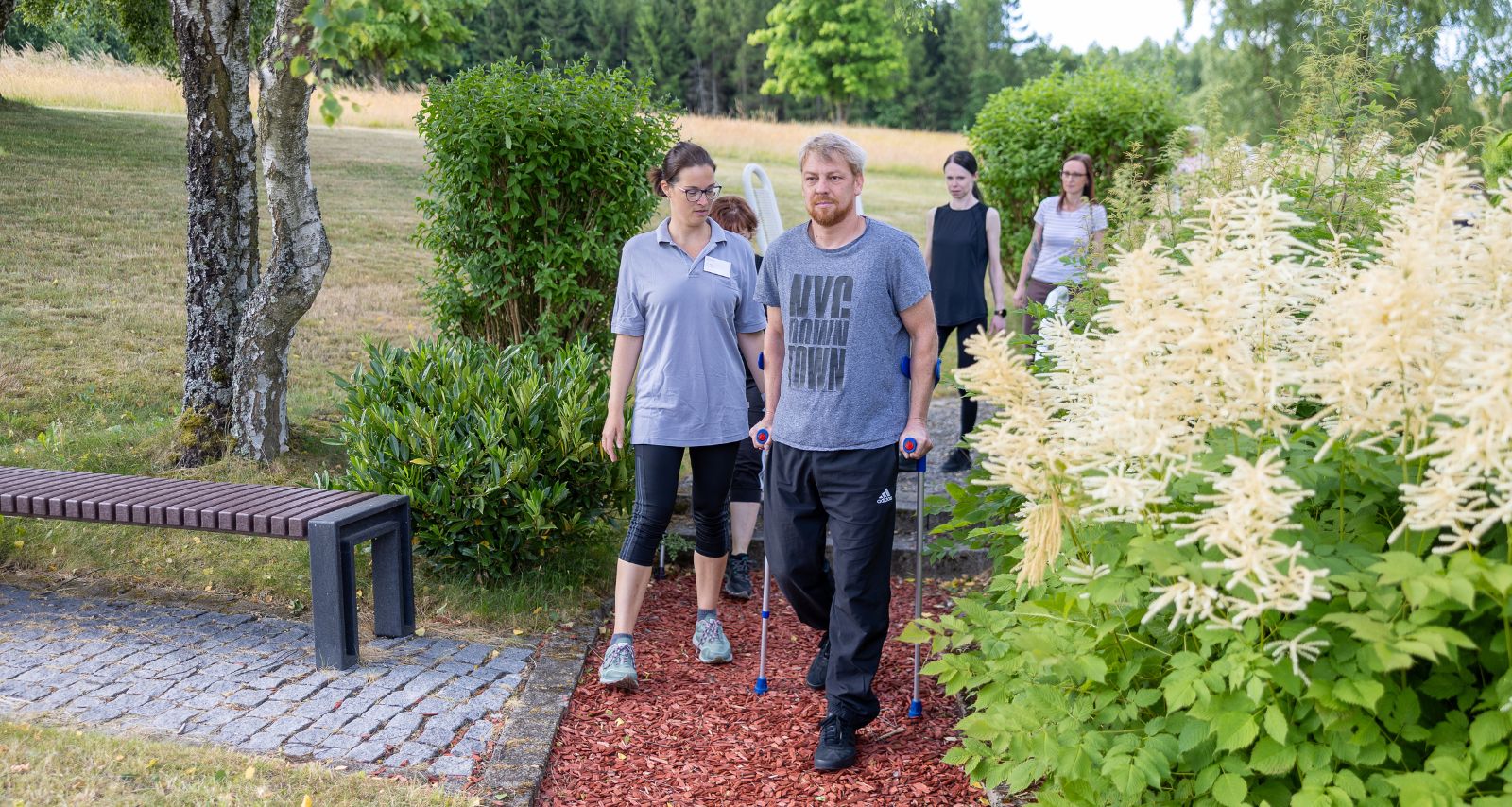 Eine Person die mit Krücken draußen läuft 