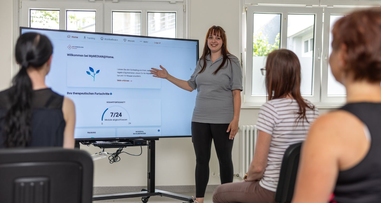 Personen die dem Vortrag der Frau zuhören 