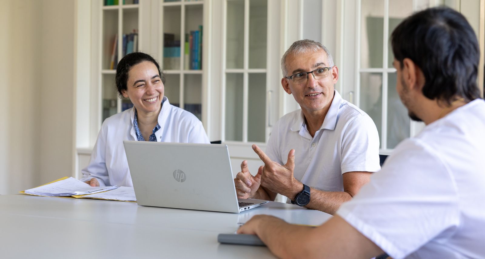 Drei Personen die gemeinsam sitzen und lächeln 
