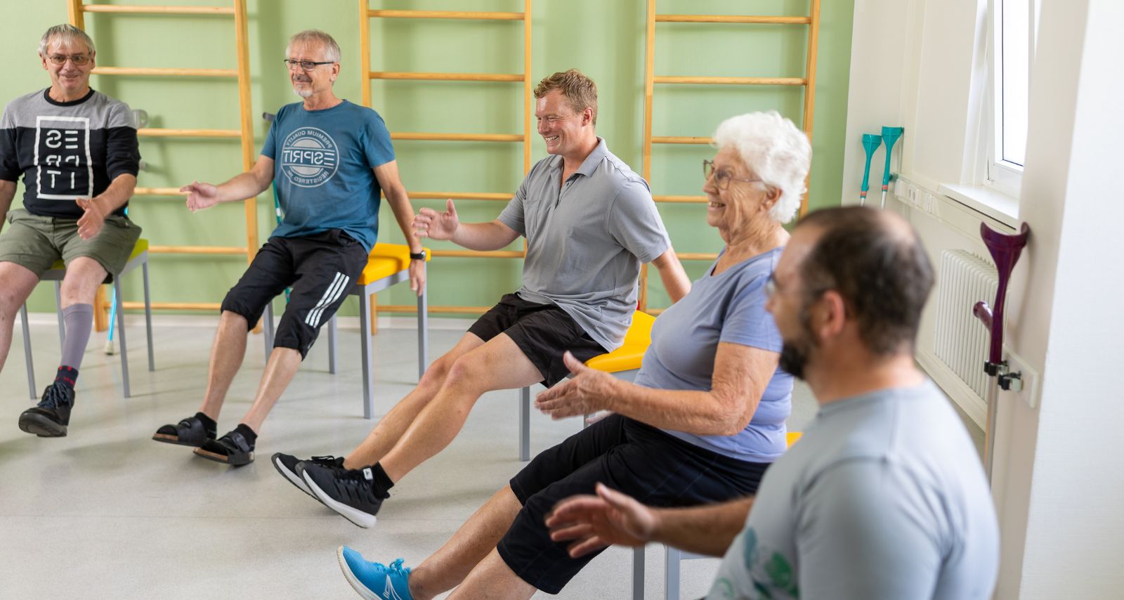 Personen die im Kreis sitzen und Übungen durchführen 