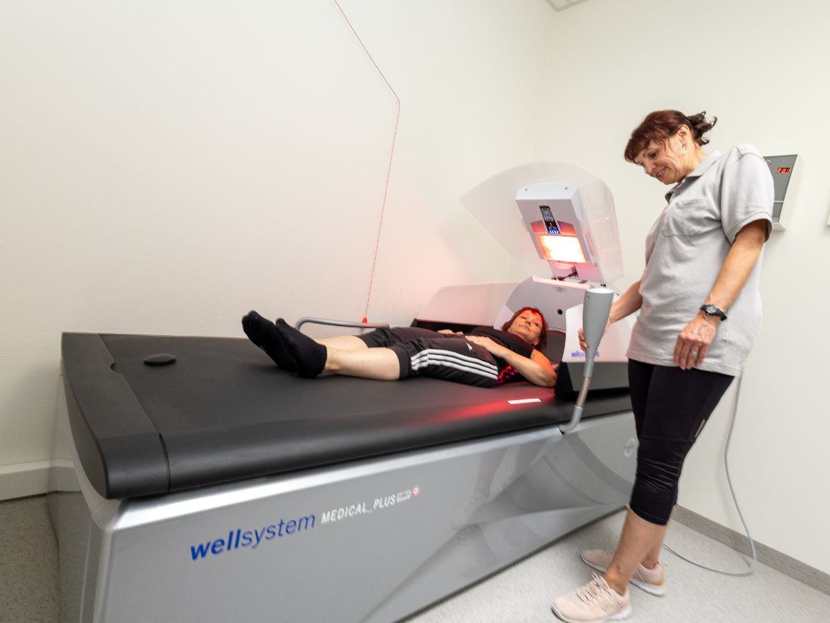 Eine Frau die auf einer Liege liegt und neben ihr steht eine andere Frau