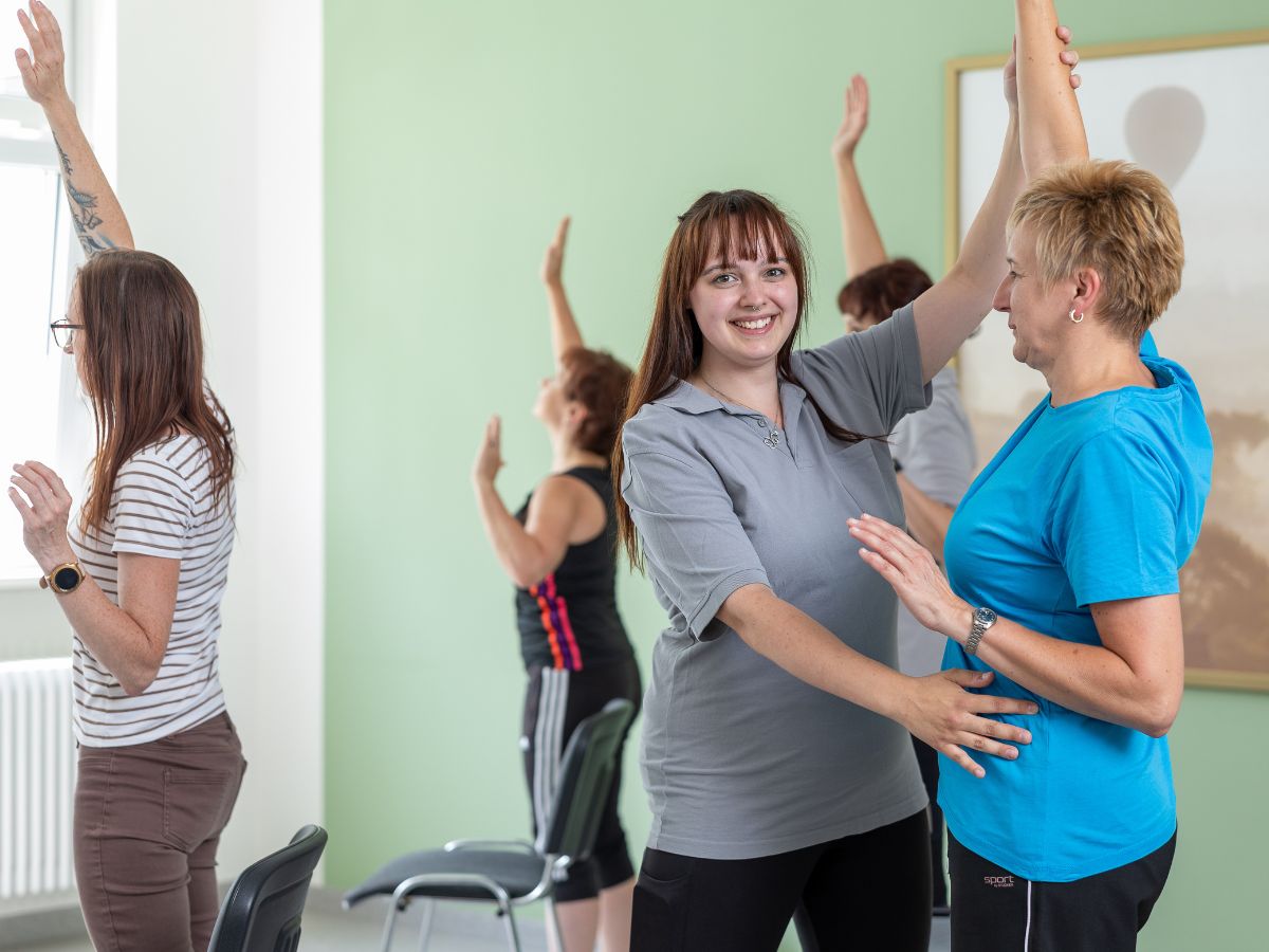 Eine Frau die einem Patienten hilft bei einer Übung 