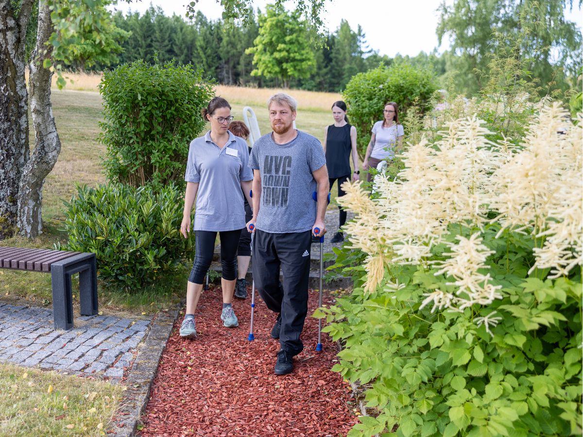 Eine Person die mit Krücken draußen läuft 
