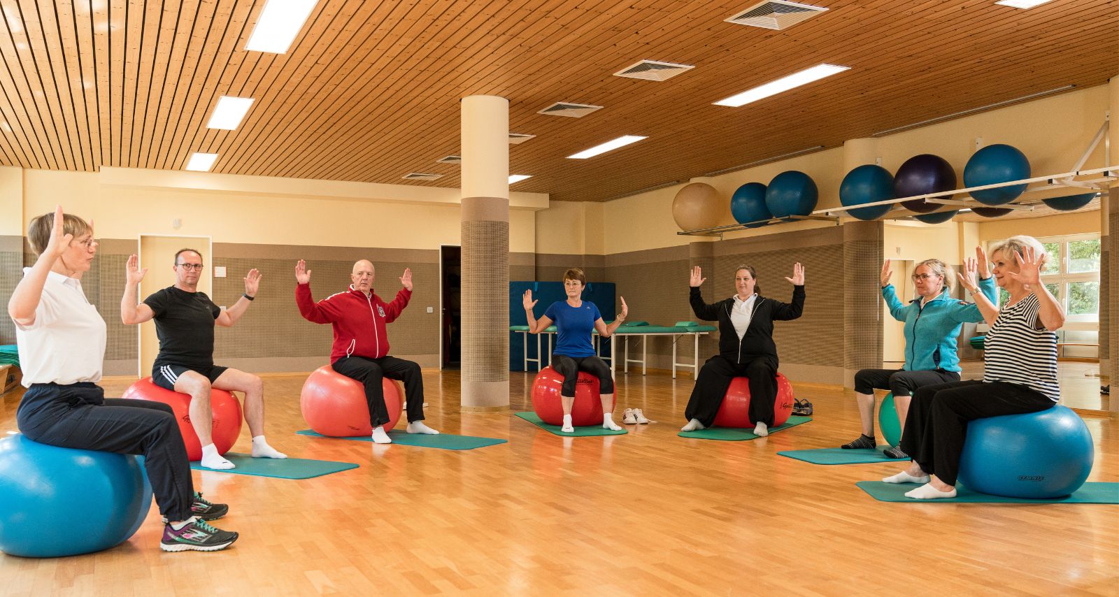 Personen die auf Gymnastikbällen sitzen 