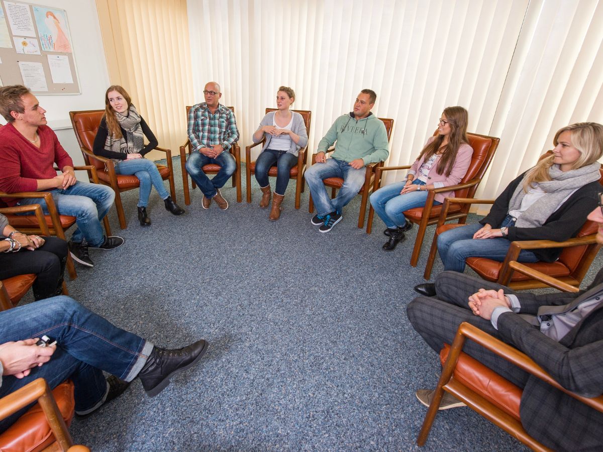 Personen die in einem Stuhlkreis sitzen 