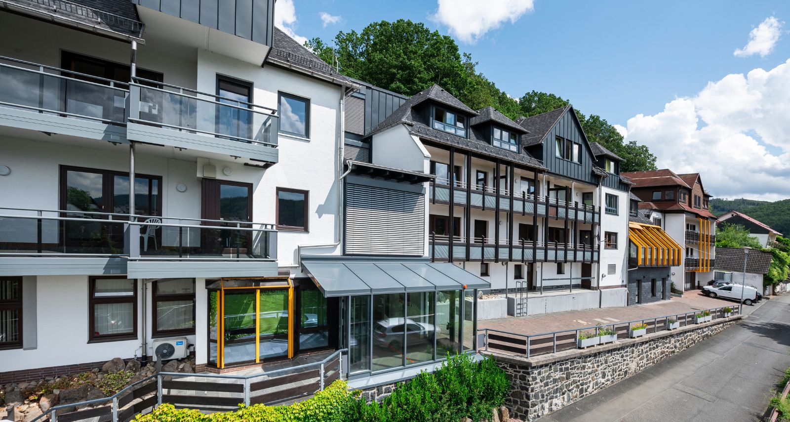 Klinikgebäude mit begrünten Flächen vor blauem Himmel