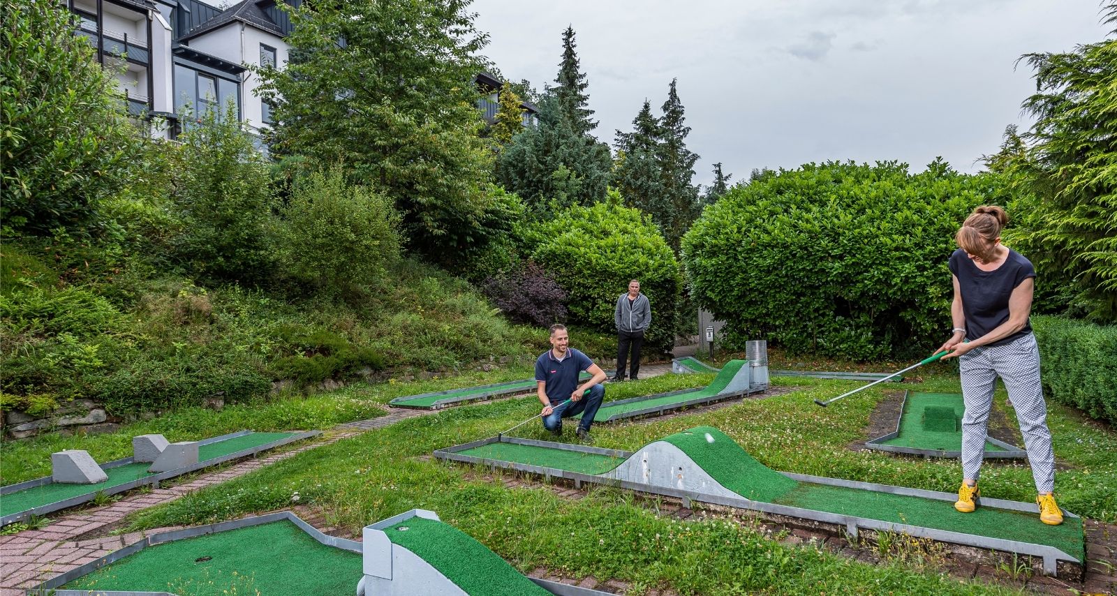 Patientin spielt Minigolf im Garten der Klinik