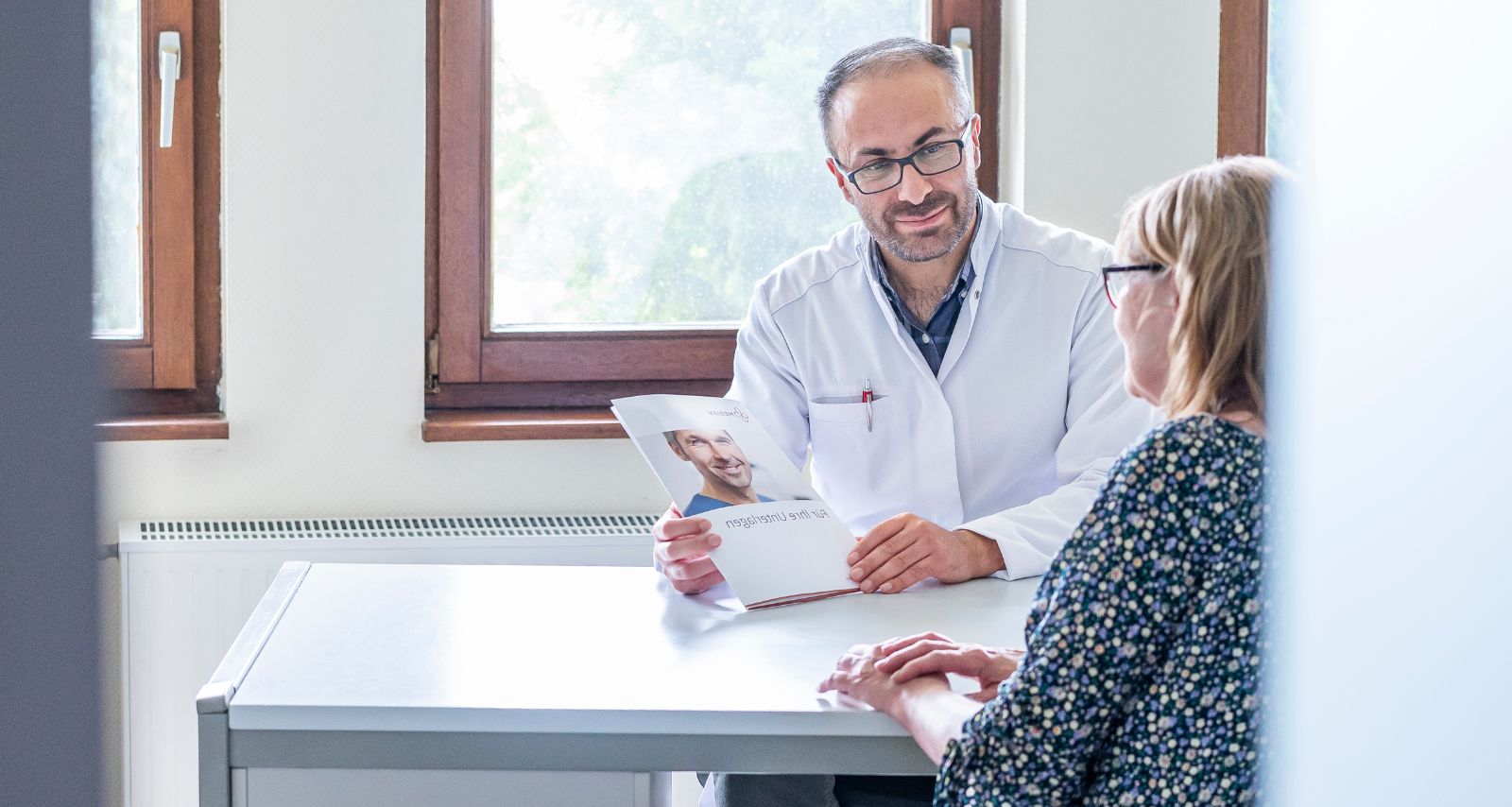 Arzt spricht mit Patienten im Arztzimmer