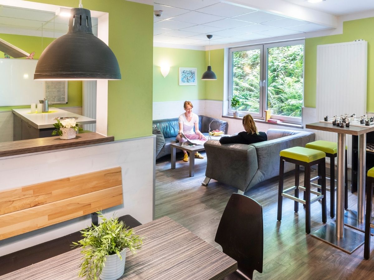 Patienten lesen in der Sofaecke im Aufenthaltsraum 