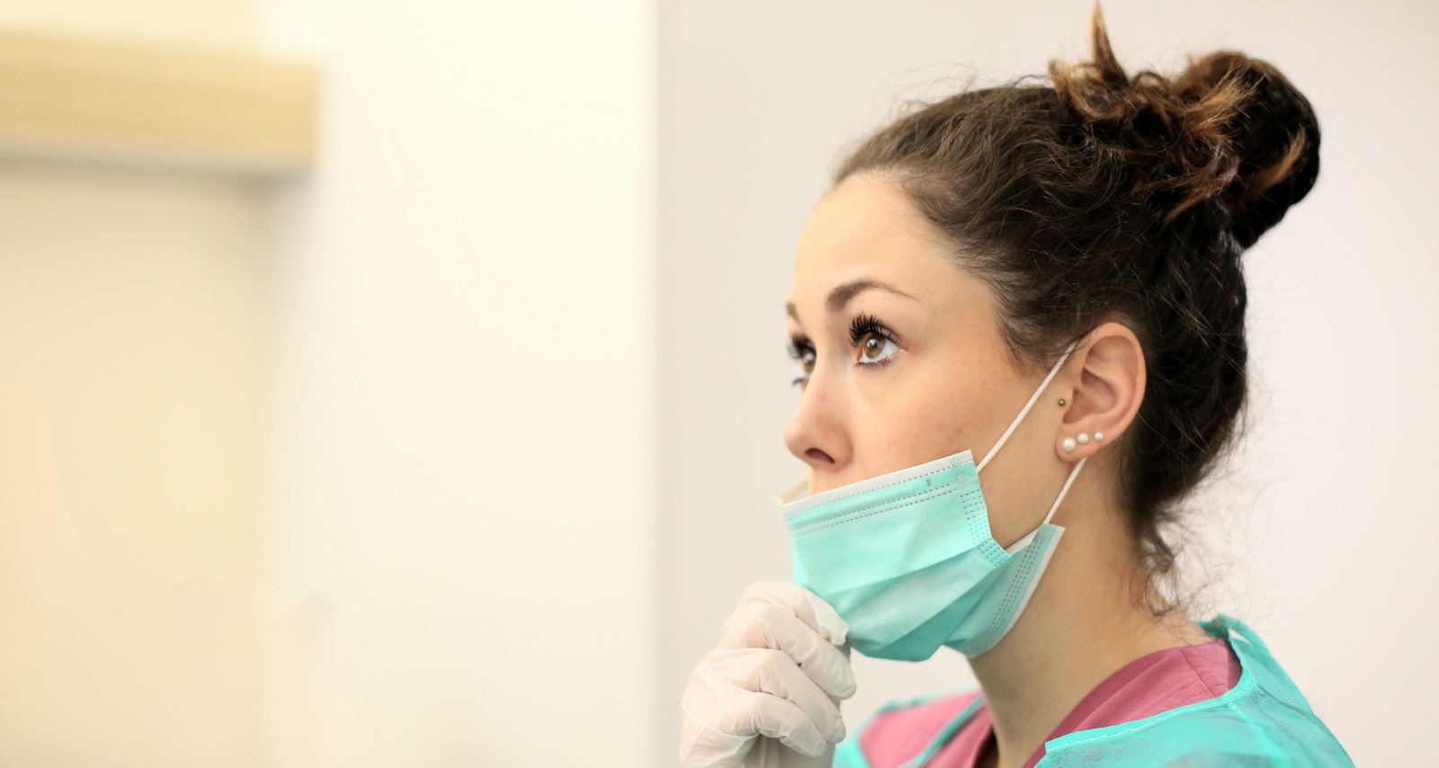 Eine Ärztin mit grüner Arbeitskleidung und Maske 