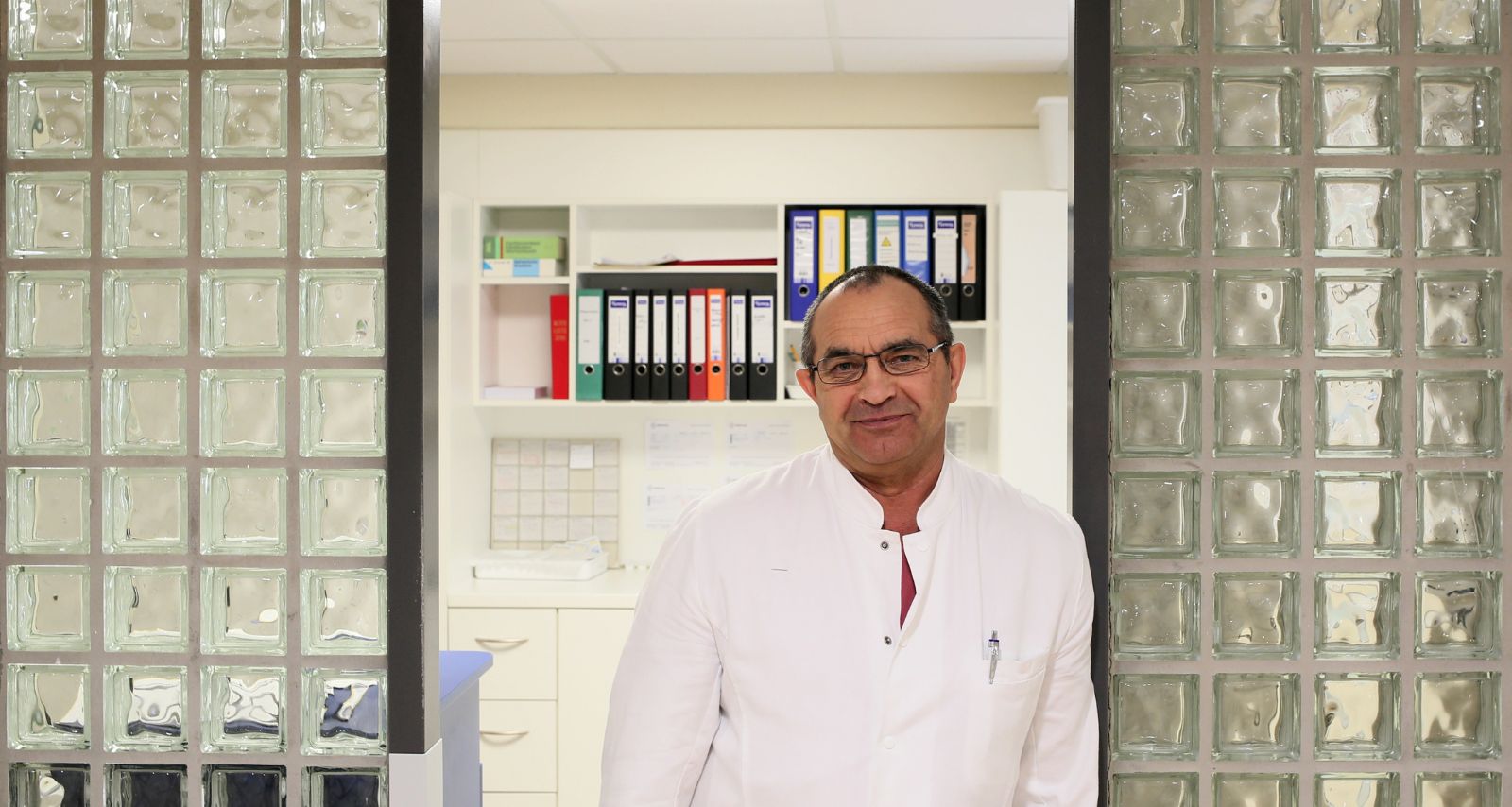 Ein Mann der sich am Tür Rahmen anlehnt und lächelt