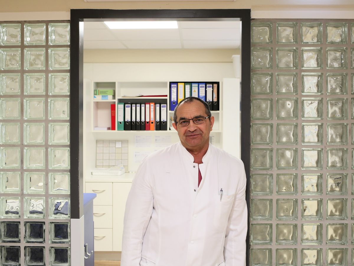 Ein Mann der sich am Tür Rahmen anlehnt und lächelt