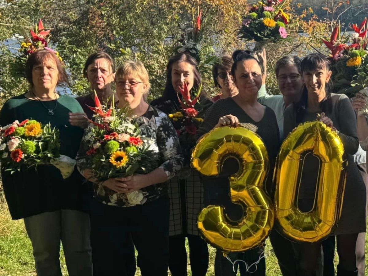 Ein Gruppenfoto bei dem ein Luftballon in Form einer 30 gehalten wird