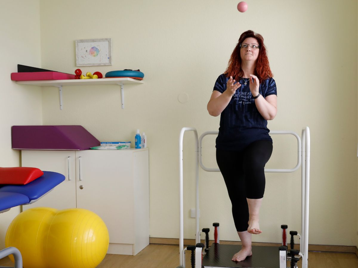 Eine Frau die ihr Gleichgewicht hält und einen Ball fängt 