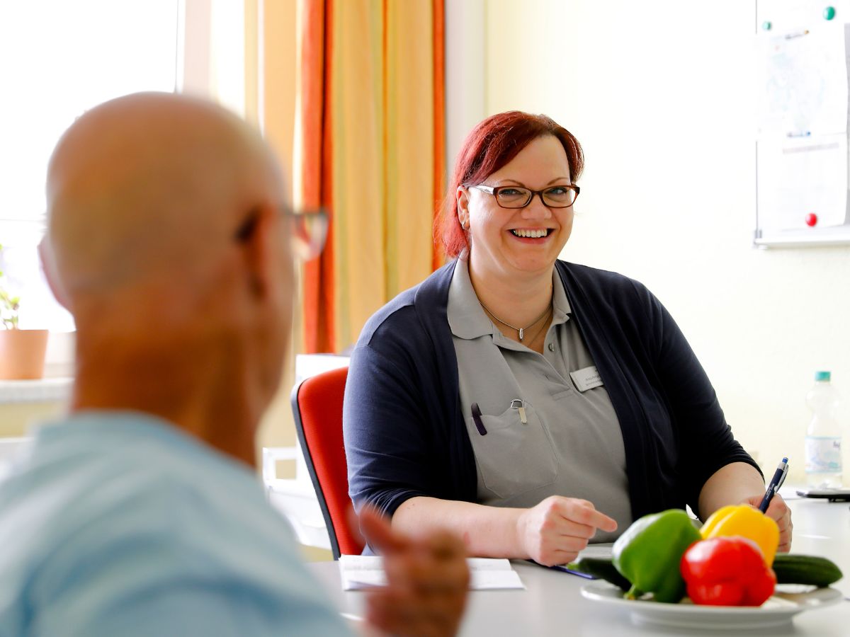 Eine Frau lächelt eine Person an 