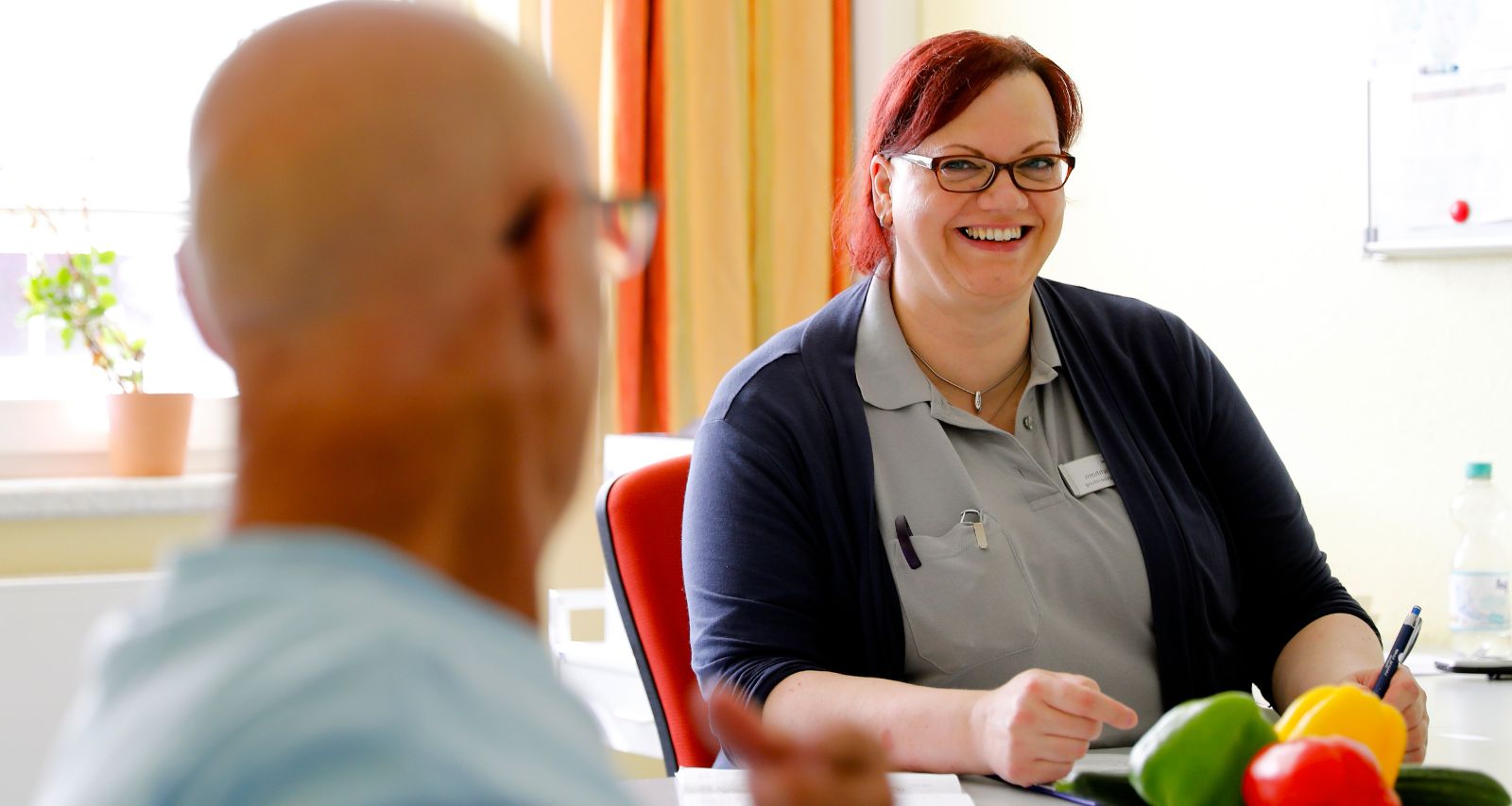 Eine Frau lächelt eine Person an 