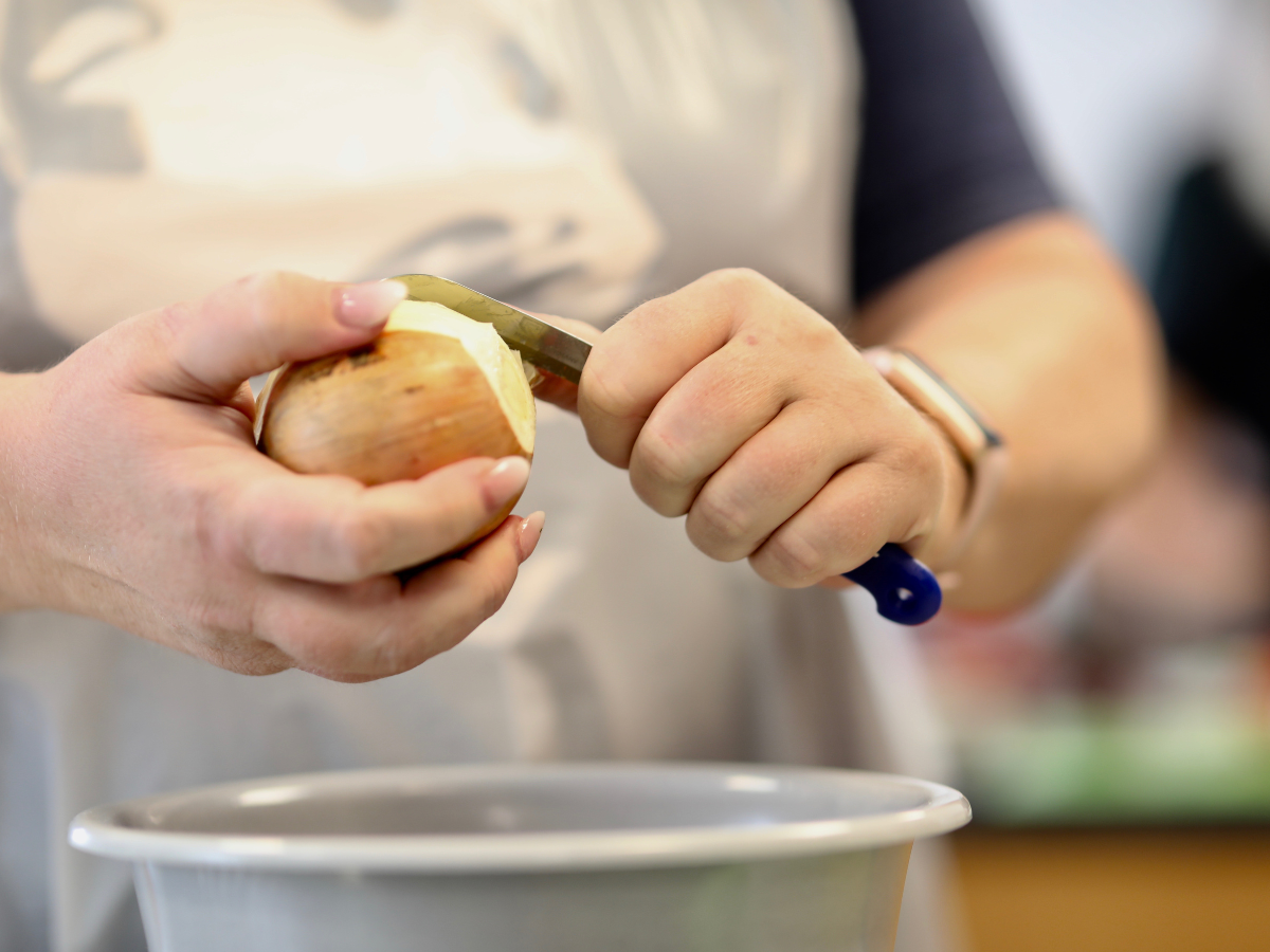 Eine Frau die eine Zwiebel schält 