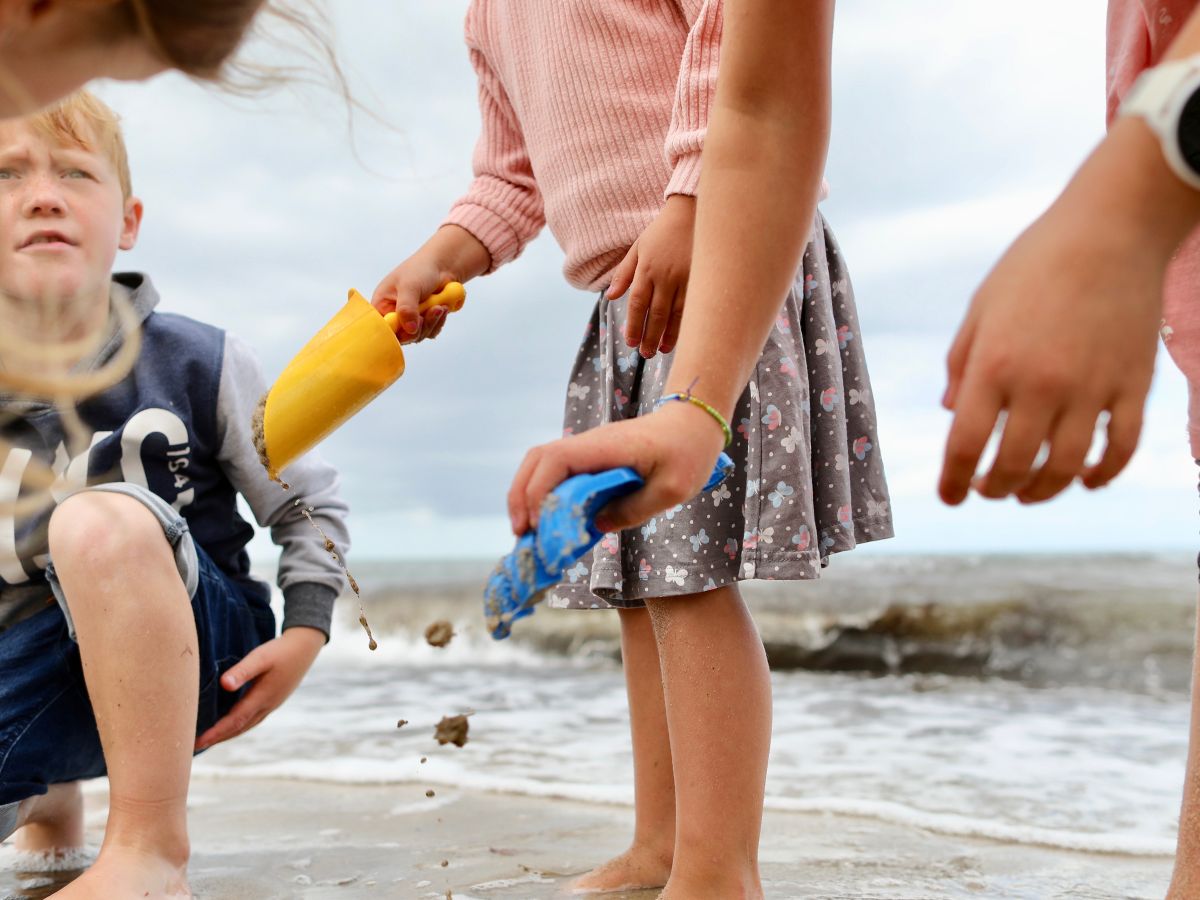 Kinder, die Barfuß am strand der Ostsee laufen und spielen.