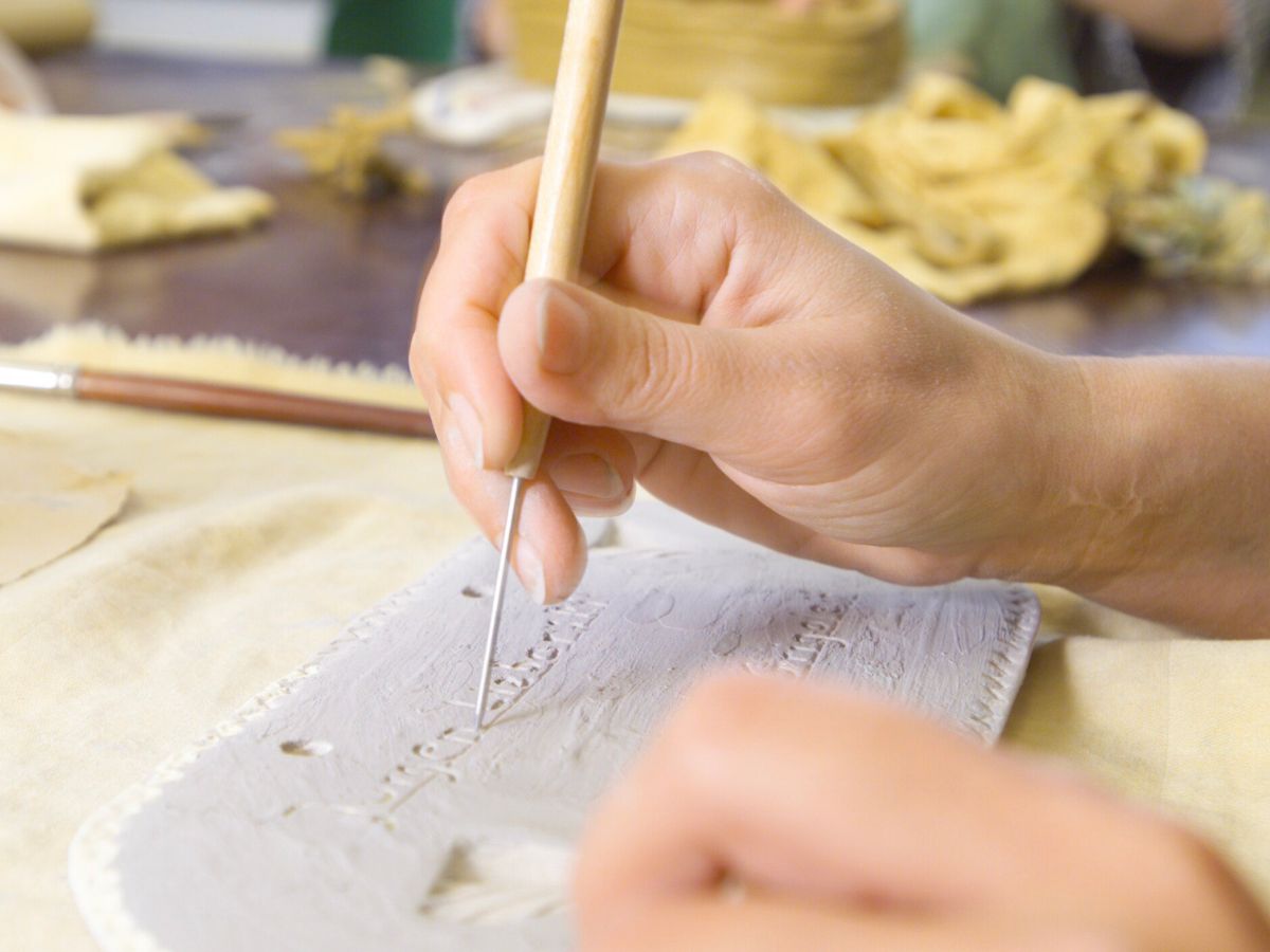 Eine Person schreibt in den Ton 