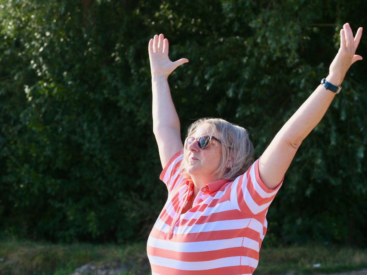 Eine Frau die ihre Hände nach oben streckt 