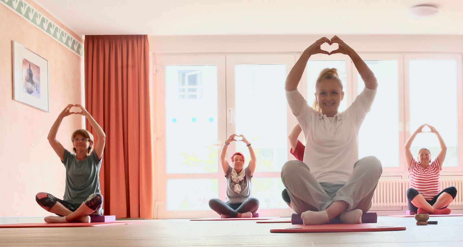 Person die Yoga betreiben und Herz mit den Händen formen 