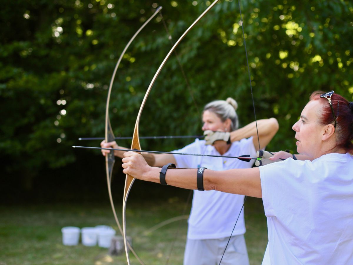 Zwei Frauen die Bogenschießen 