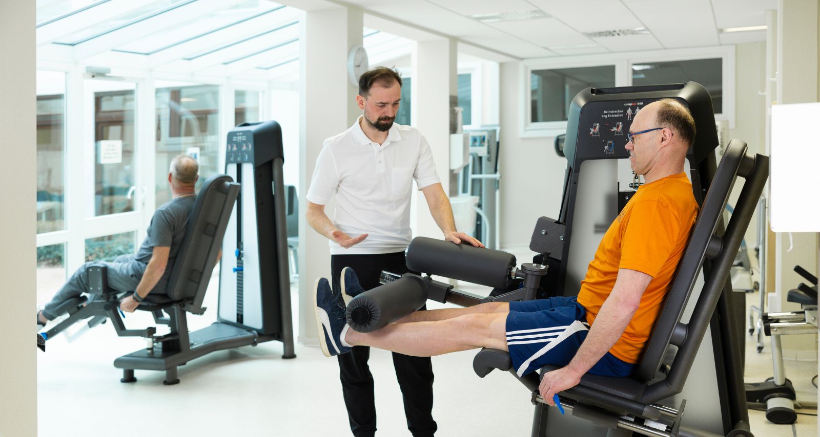 Der Therapeut hilft dem Patienten in der Turnhalle
