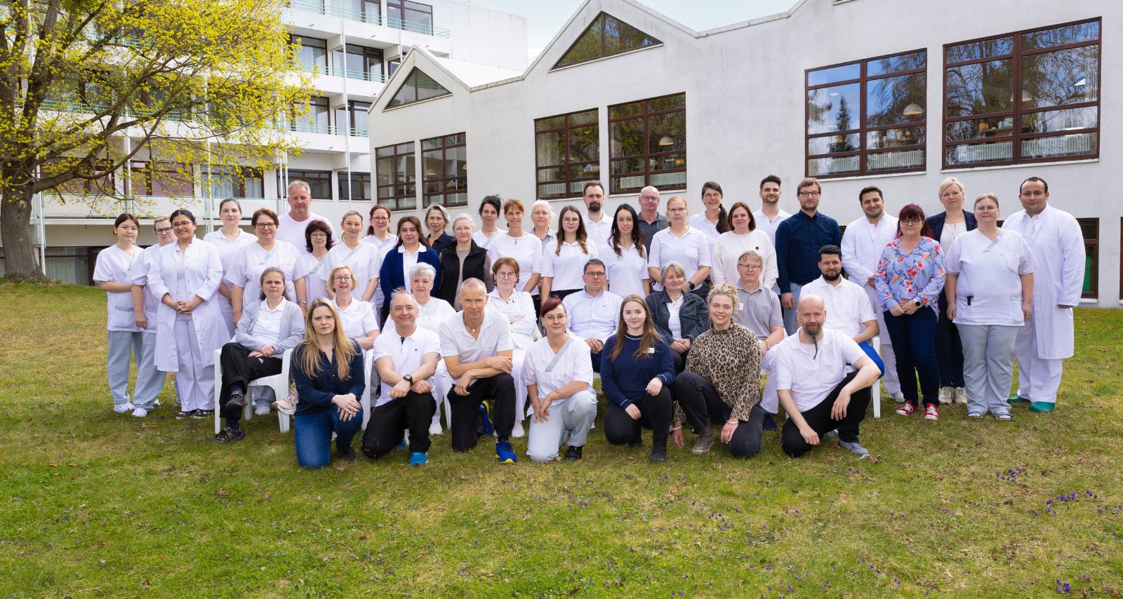 Eine Gruppe von Mitarbeitenden steht vor der Klinik