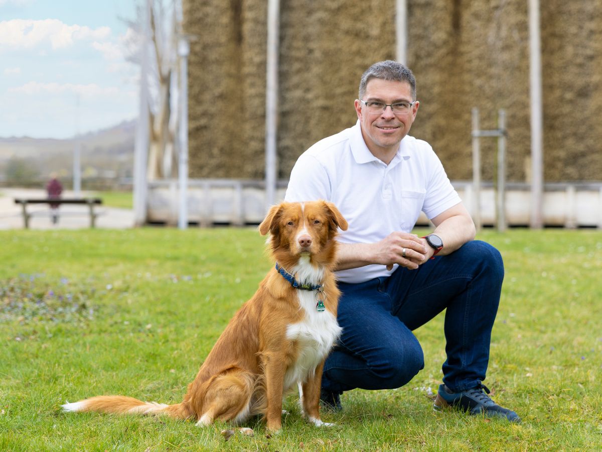 Ein Mann mit dem Hund draußen