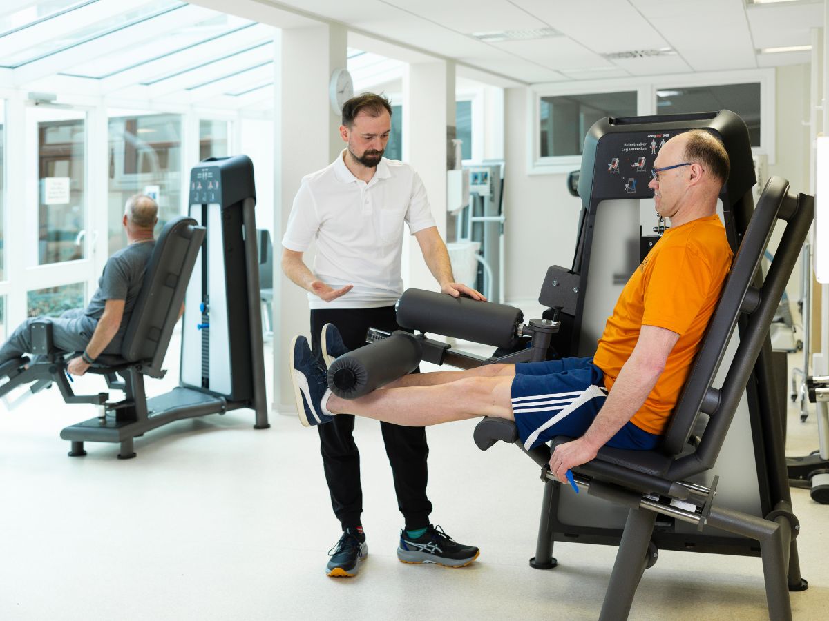 Der Therapeut hilft dem Patienten in der Turnhalle