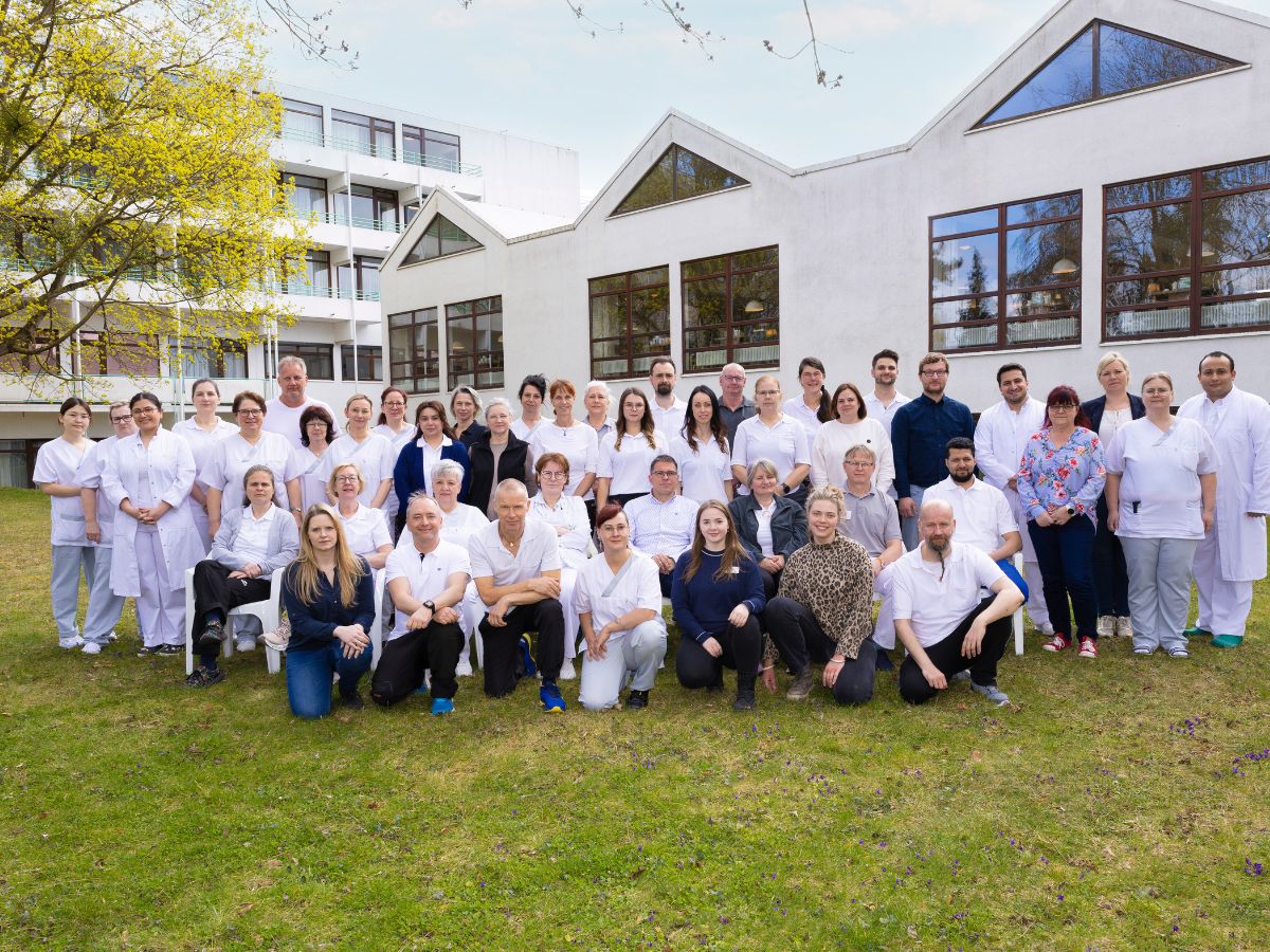 Eine Gruppe von Mitarbeitenden steht vor der Klinik