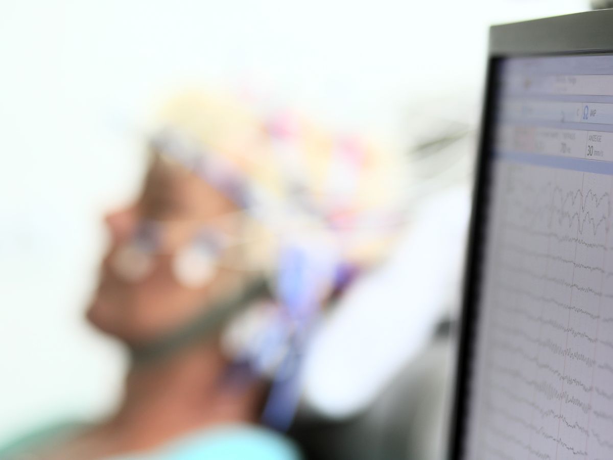 Eine Frau die liegt und neben ihr befindet sich ein Computer 