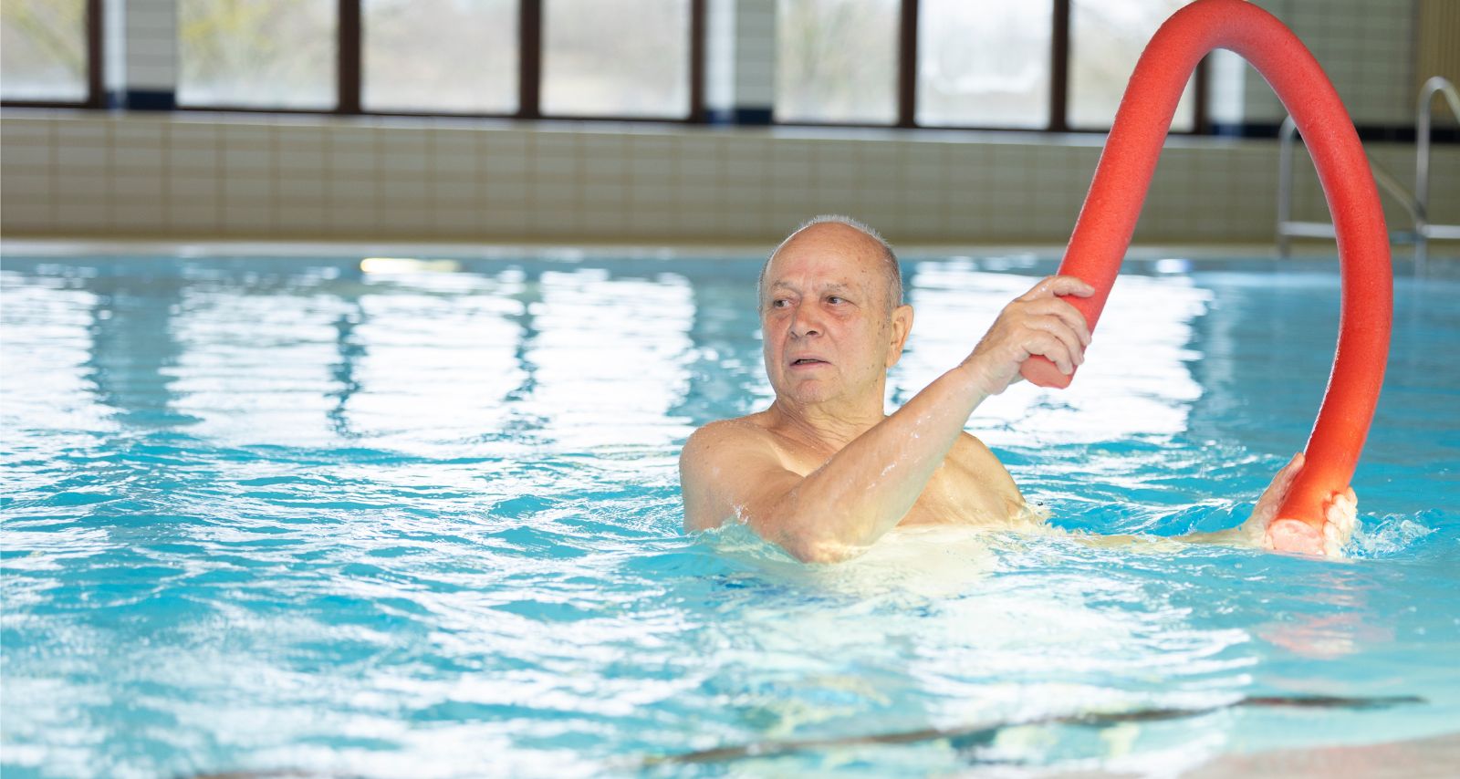 Ein Mann bewegt sich im Schwimmbad