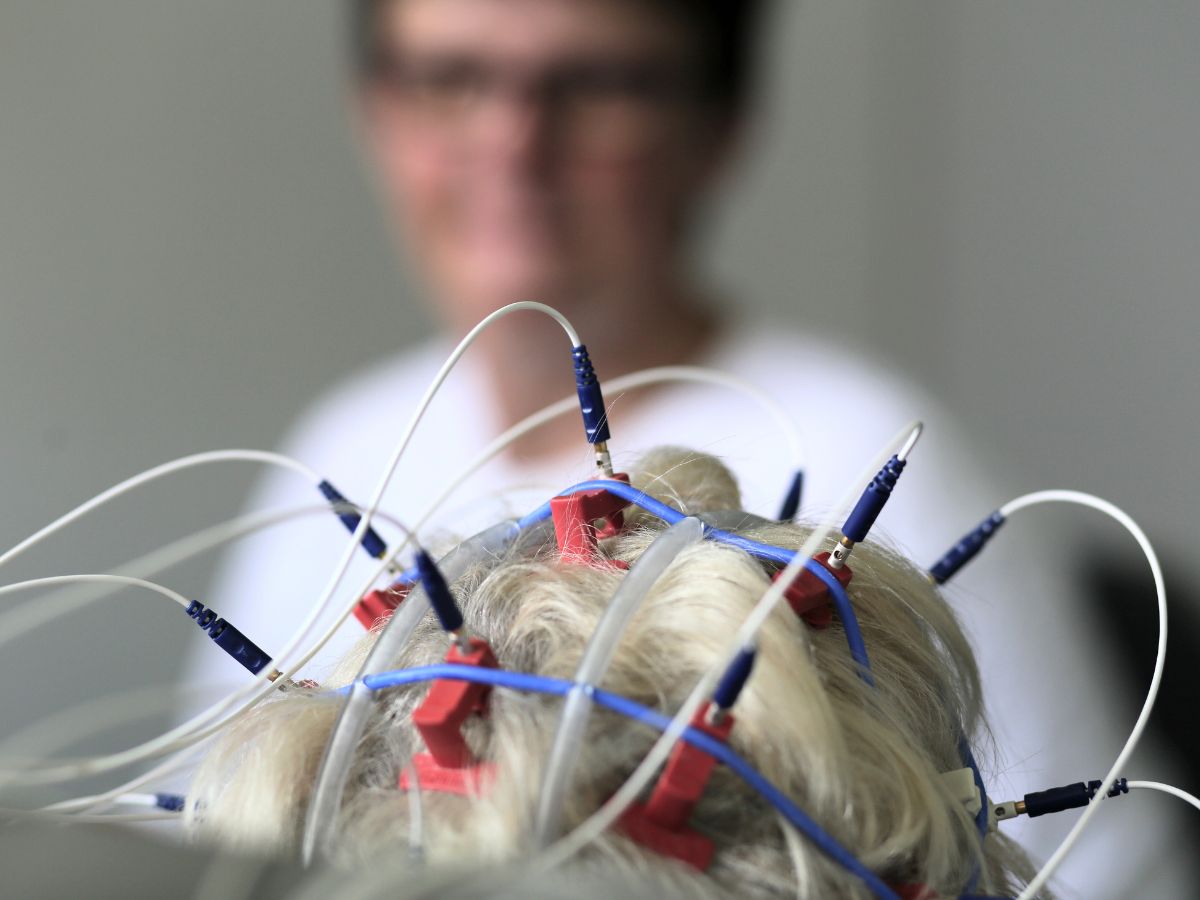 Eine Person die an ihrem Kopf Drähte angeschlossen hat 